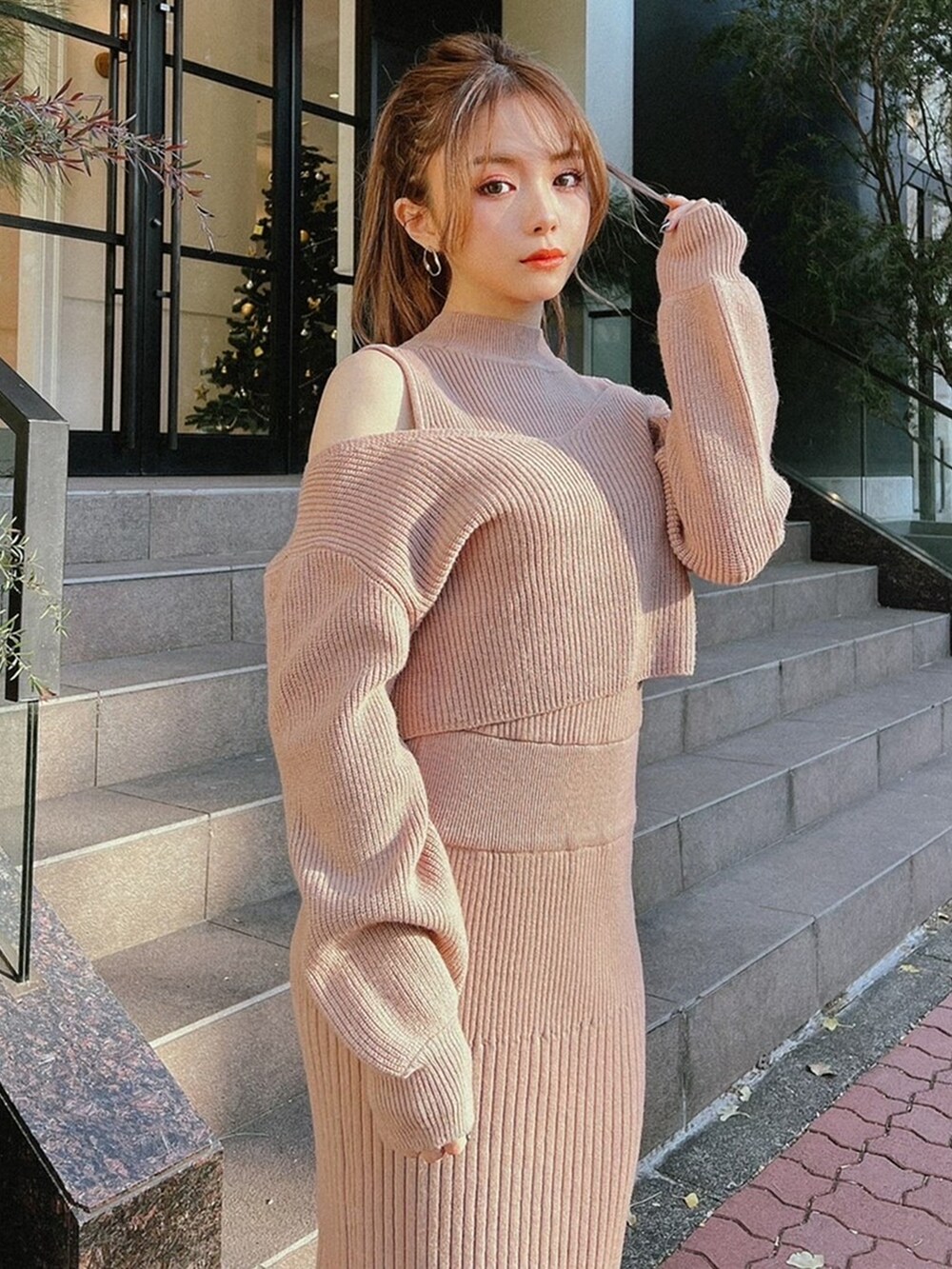 ピンク系のワンピース、ブラック系のブーツを着用したレディースの冬コーディネートの3枚目の写真