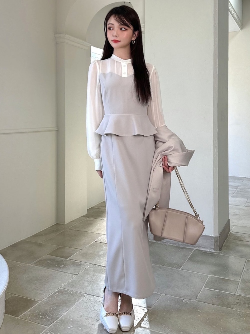 ベージュ系のワンピース、ベージュ系のテーラードジャケット、ベージュ系のハンドバッグを着用したレディースの冬コーディネートの4枚目の写真