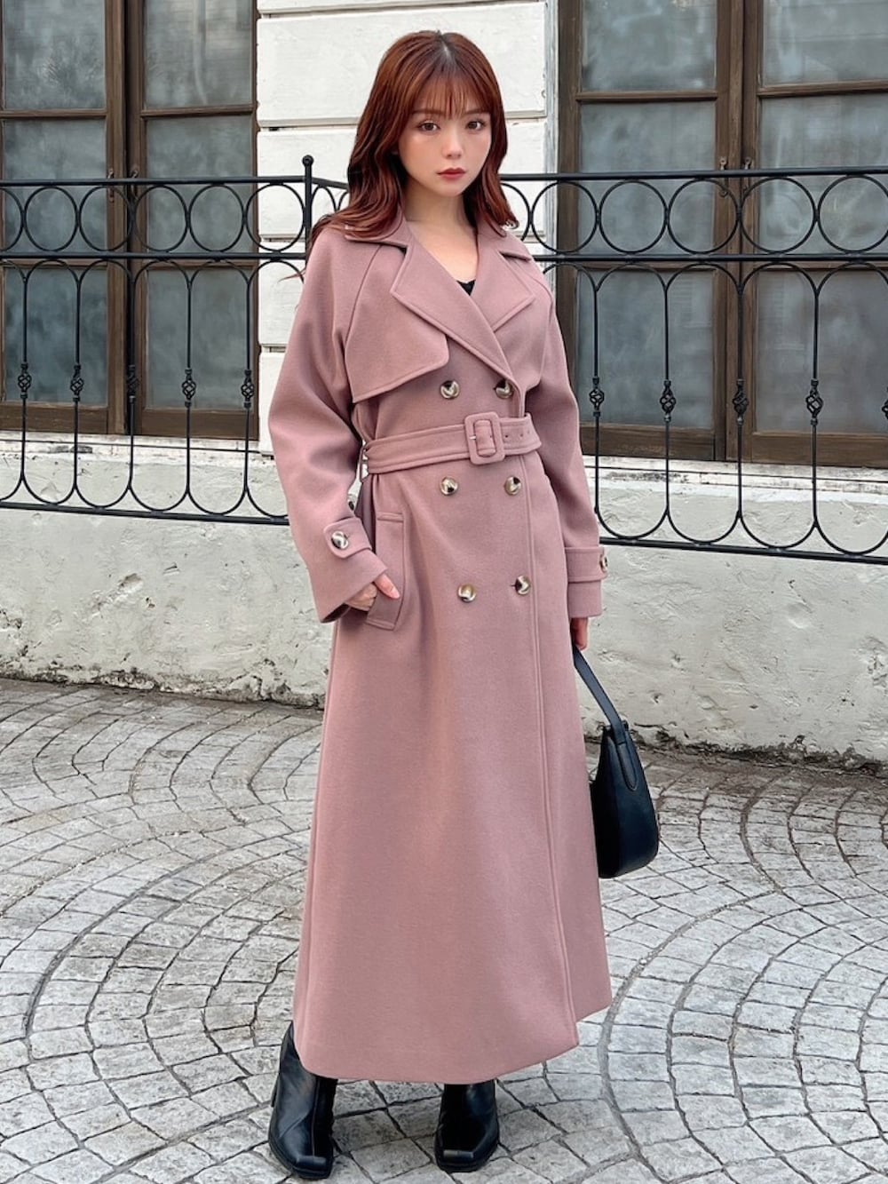 ピンク系のその他アウター、ブラック系のワンピース、ブラック系のハンドバッグを着用したレディースの冬コーディネートの4枚目の写真