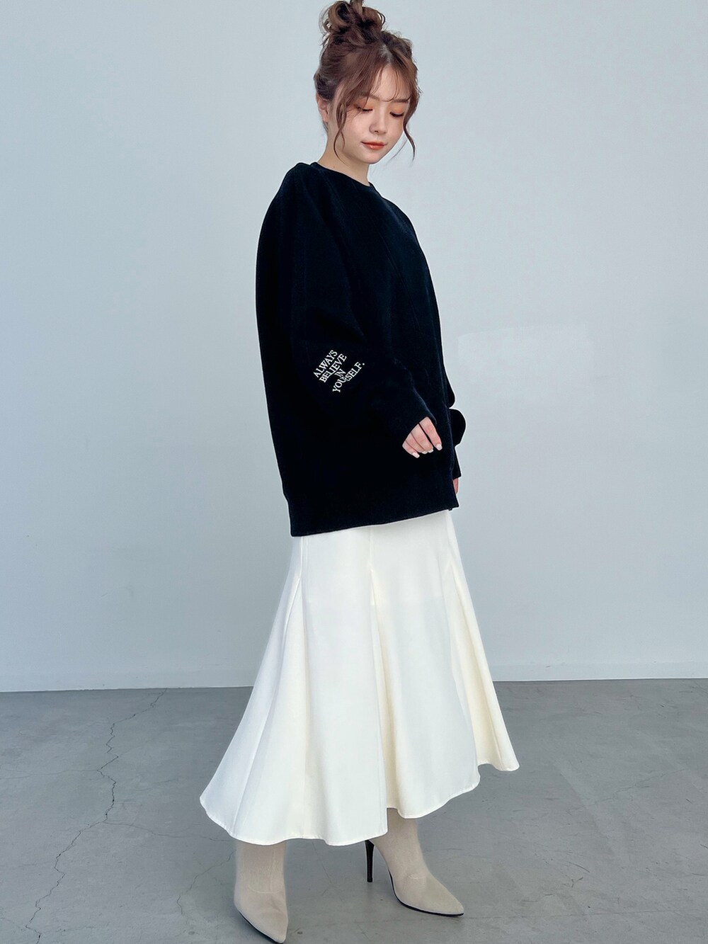 ホワイト系のブーツ、ホワイト系のスカートを着用したレディースの秋コーディネートの3枚目の写真