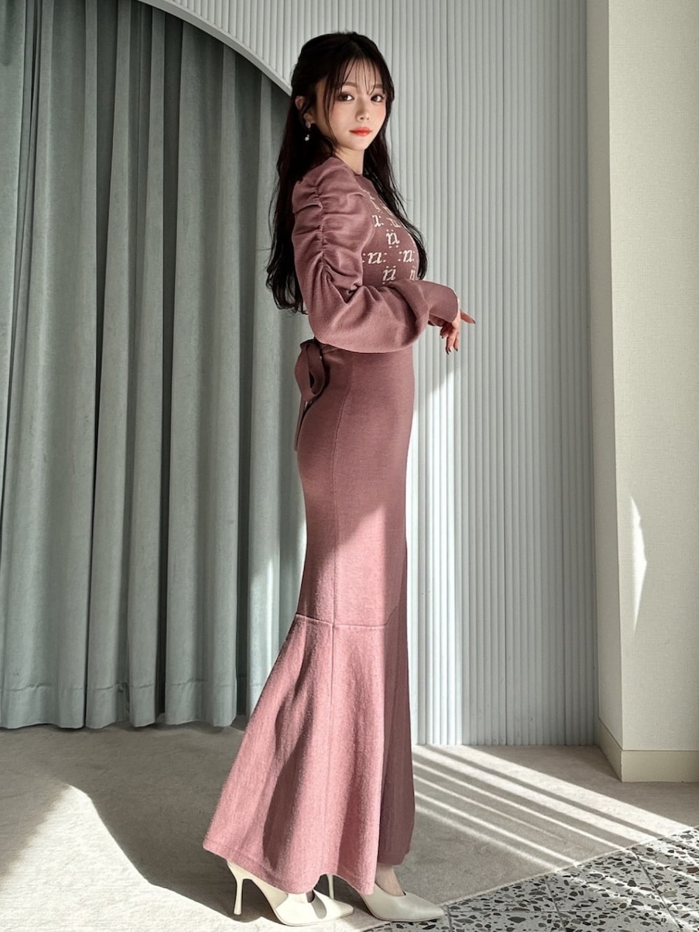 ブラウン系のワンピース、ホワイト系のパンプス、ホワイト系のハンドバッグを着用したレディースの冬コーディネートの2枚目の写真