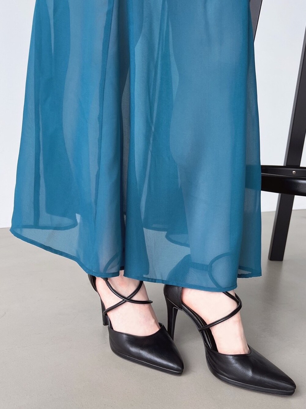 グリーン系のスカート、ブラック系のパンプス、ブラック系のニット/セーターを着用したレディースの夏コーディネートの4枚目の写真