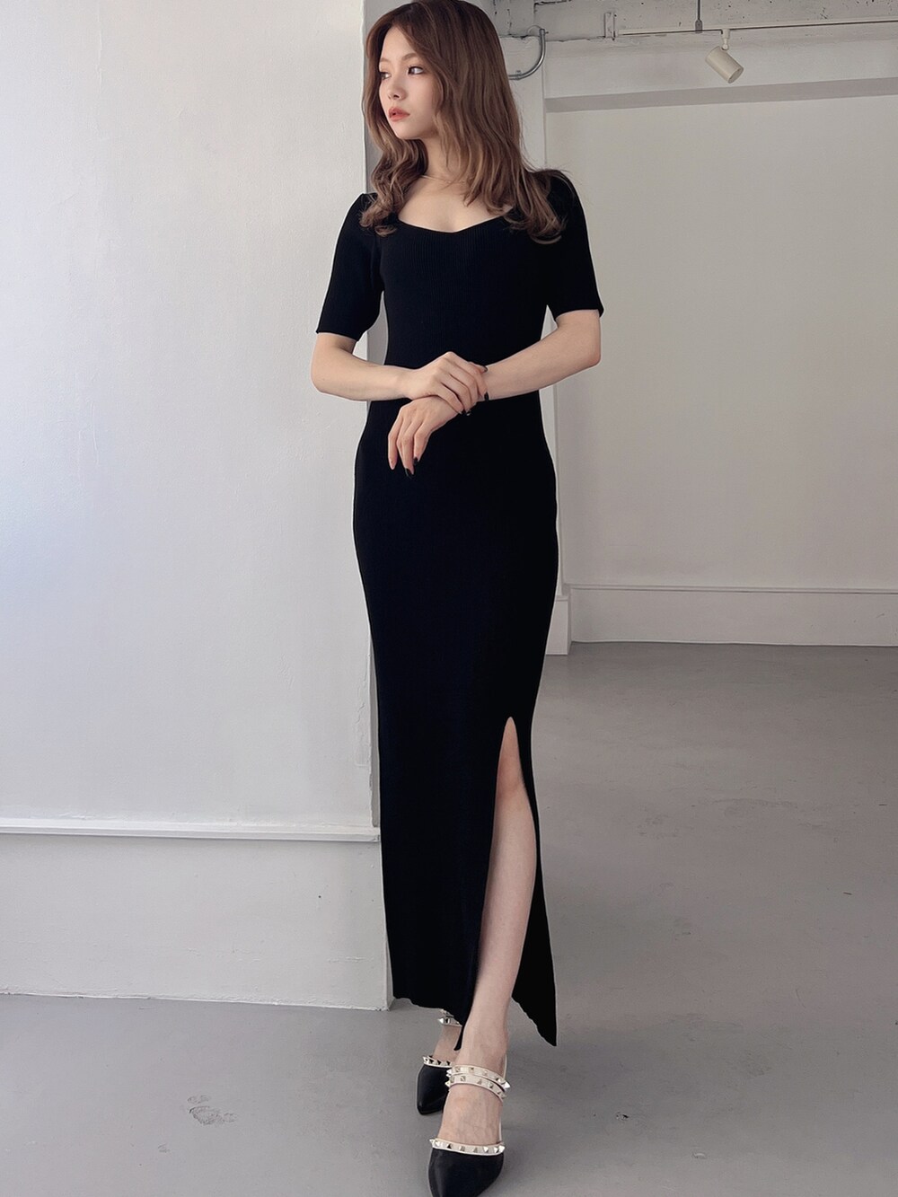 ブラック系のワンピース、ブラック系のパンプスを着用したレディースの夏コーディネートの3枚目の写真