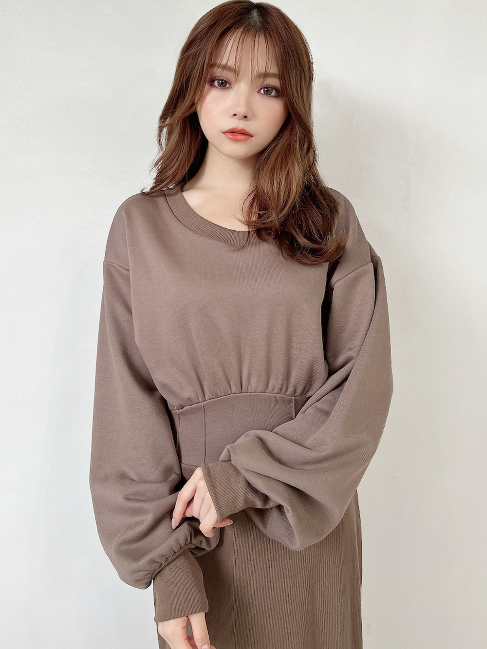 ベージュ系のワンピース、ブラック系のパンプスを着用したレディースの秋コーディネートの3枚目の写真