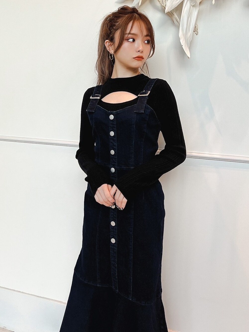 ブラック系のニット/セーター、ブルー系のジャンパースカート、ベージュ系のサンダルを着用したレディースの冬コーディネートの3枚目の写真