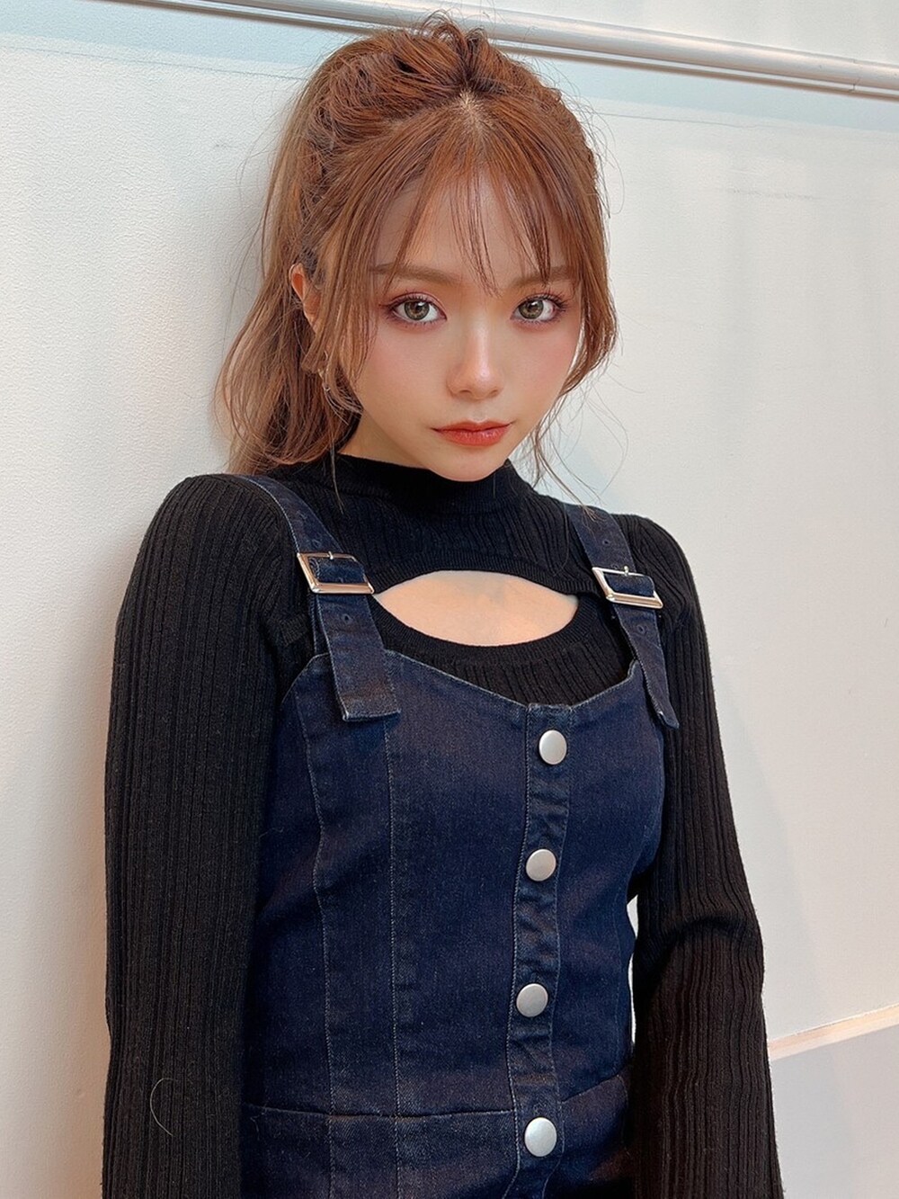 ブラック系のニット/セーター、ブルー系のジャンパースカート、ベージュ系のサンダルを着用したレディースの冬コーディネートの5枚目の写真