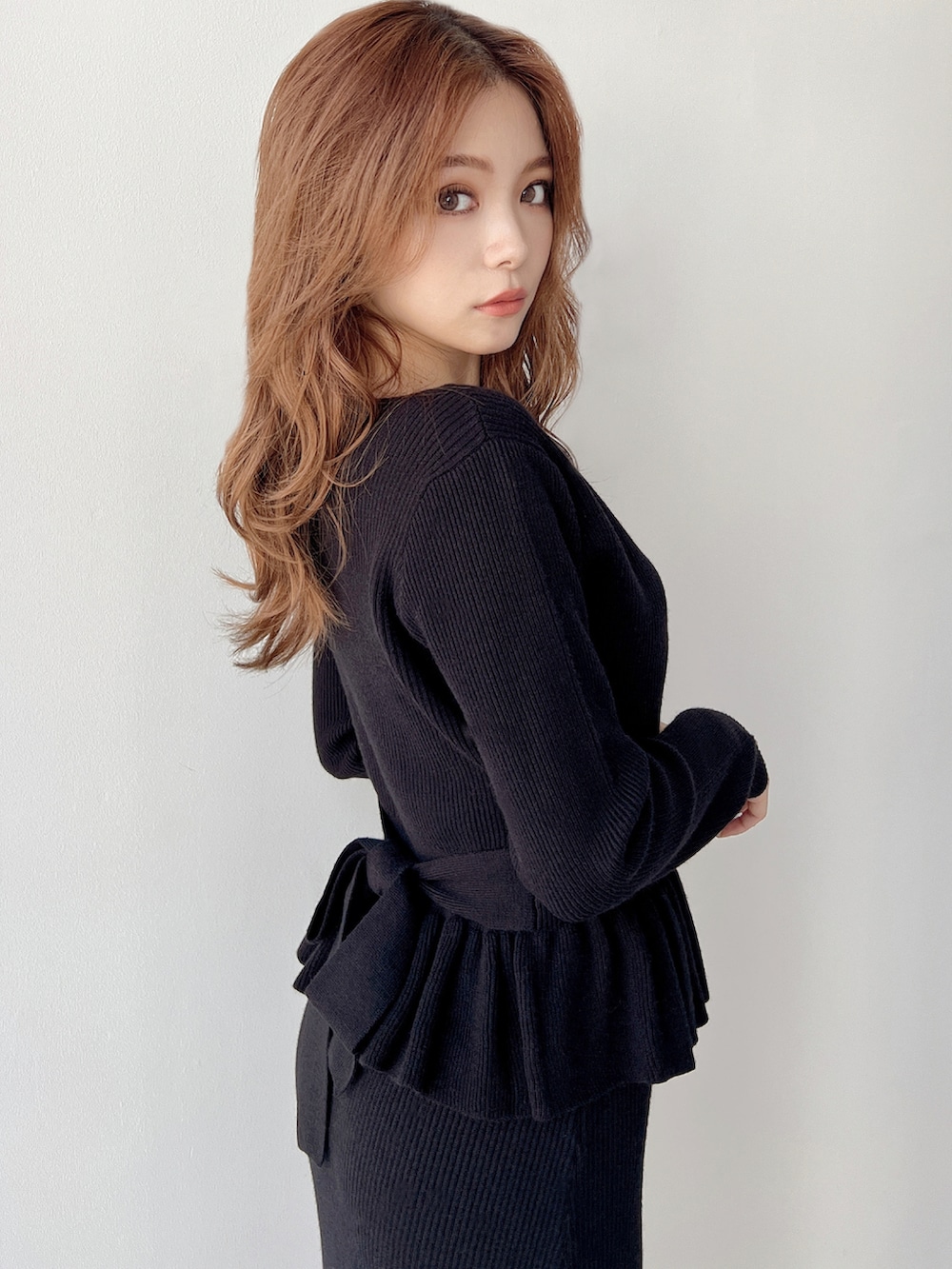 ブラック系のスカート、ブラック系のニット/セーター、ブラック系のパンプスを着用したレディースの秋コーディネートの3枚目の写真