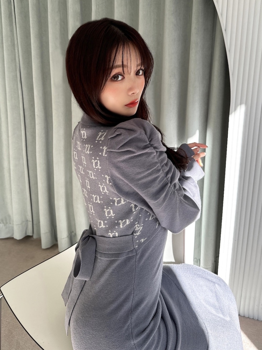 ブルー系のワンピース、ブラック系のハンドバッグ、ブラック系のパンプスを着用したレディースの冬コーディネートの3枚目の写真