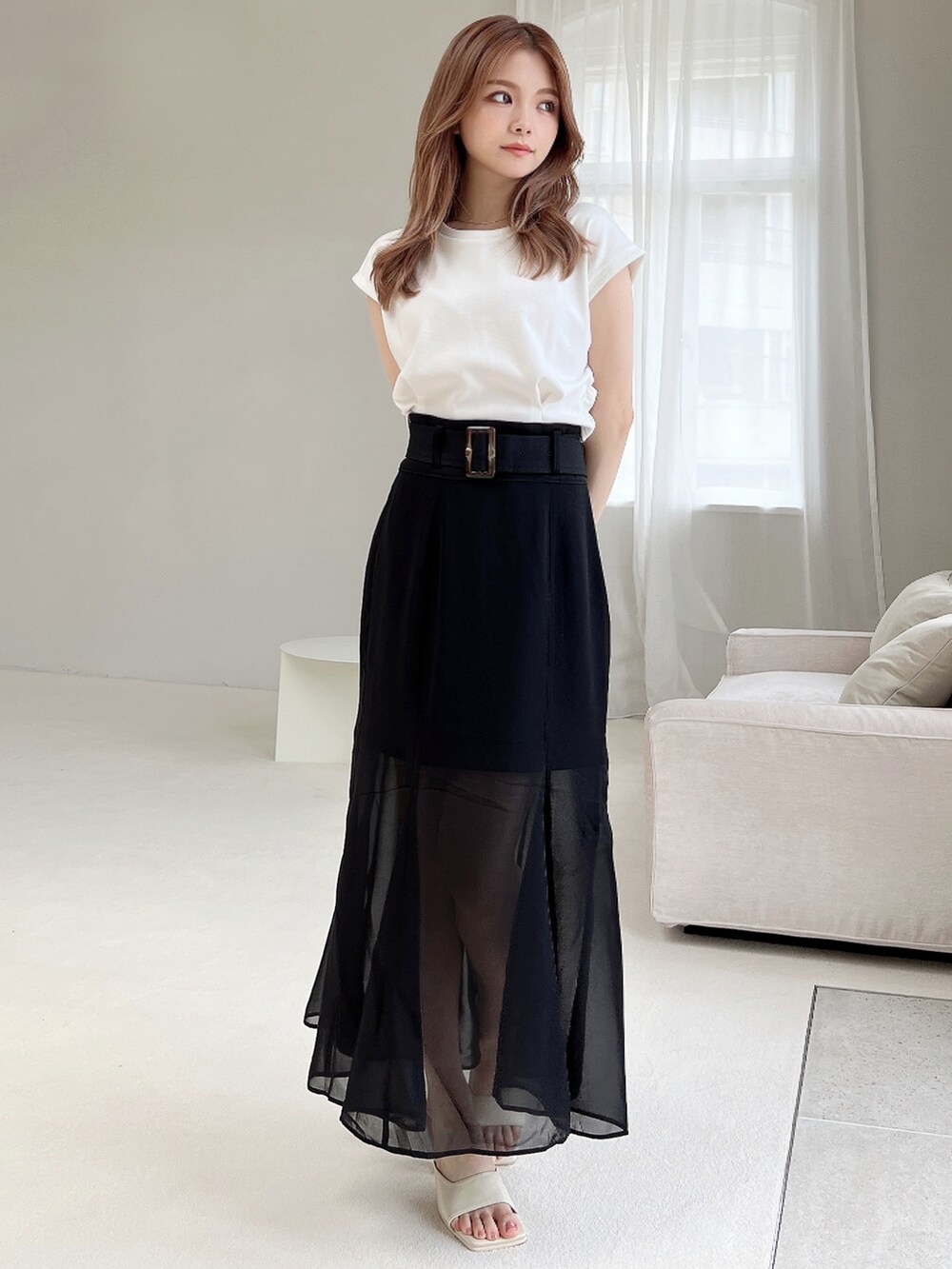 ホワイト系のTシャツ/カットソー、ホワイト系のサンダル、ブラック系のスカートを着用したレディースの夏コーディネートの3枚目の写真