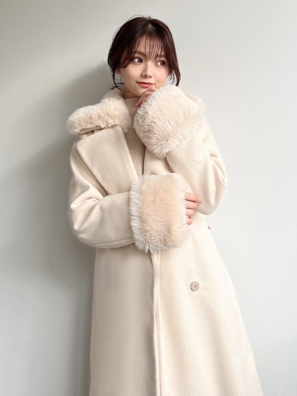 ホワイト系のその他アウター、ベージュ系のニット/セーター、ブラウン系のスカートを着用したレディースの冬コーディネートの5枚目の写真