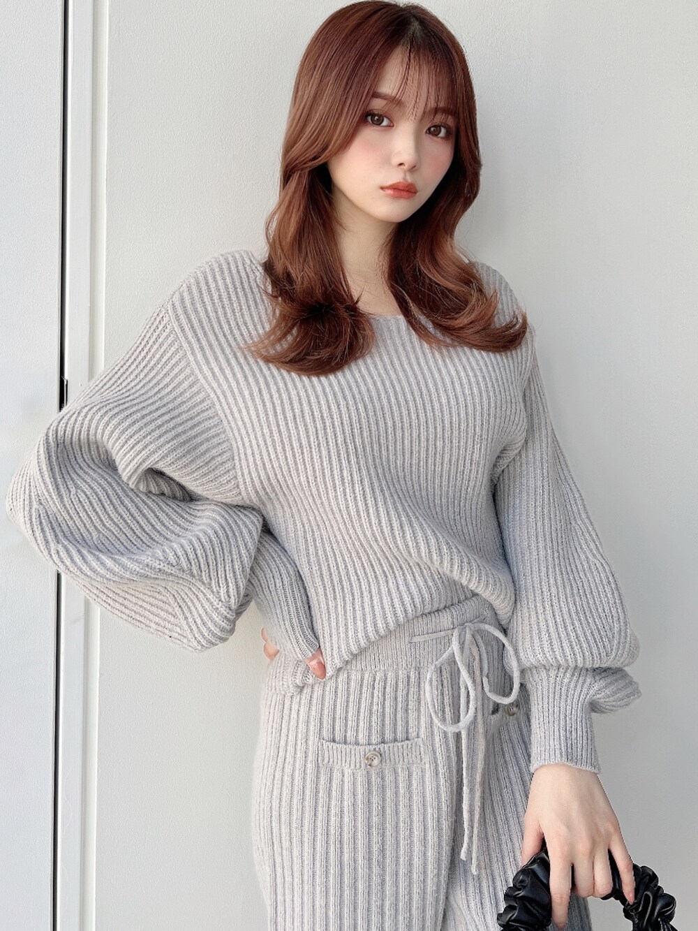 グレー系のニット/セーター、グレー系のその他パンツ、ブラック系のハンドバッグを着用したレディースの秋コーディネートの3枚目の写真