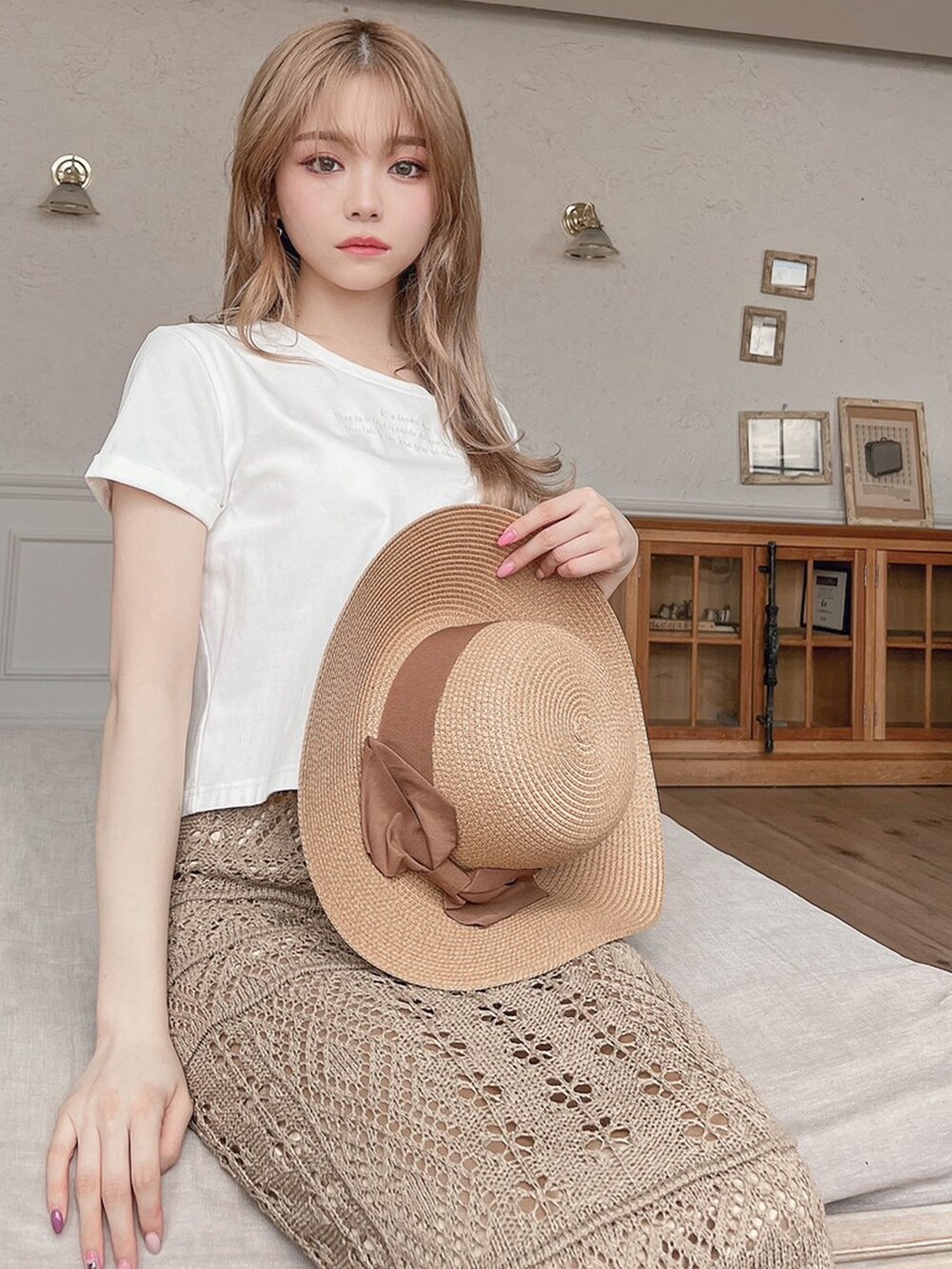 ブラウン系のサンダル、ホワイト系のTシャツ/カットソー、ベージュ系のスカートを着用したレディースの春コーディネートの2枚目の写真