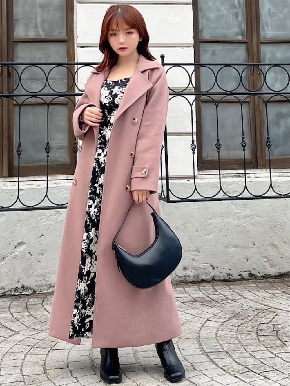 ピンク系のその他アウター、ブラック系のワンピース、ブラック系のハンドバッグを着用したレディースの冬コーディネートの2枚目の写真