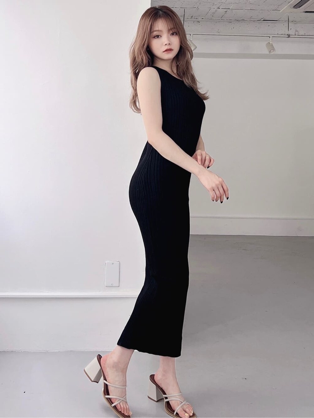 ブラック系のワンピース、ベージュ系のサンダルを着用したレディースの夏コーディネートの2枚目の写真