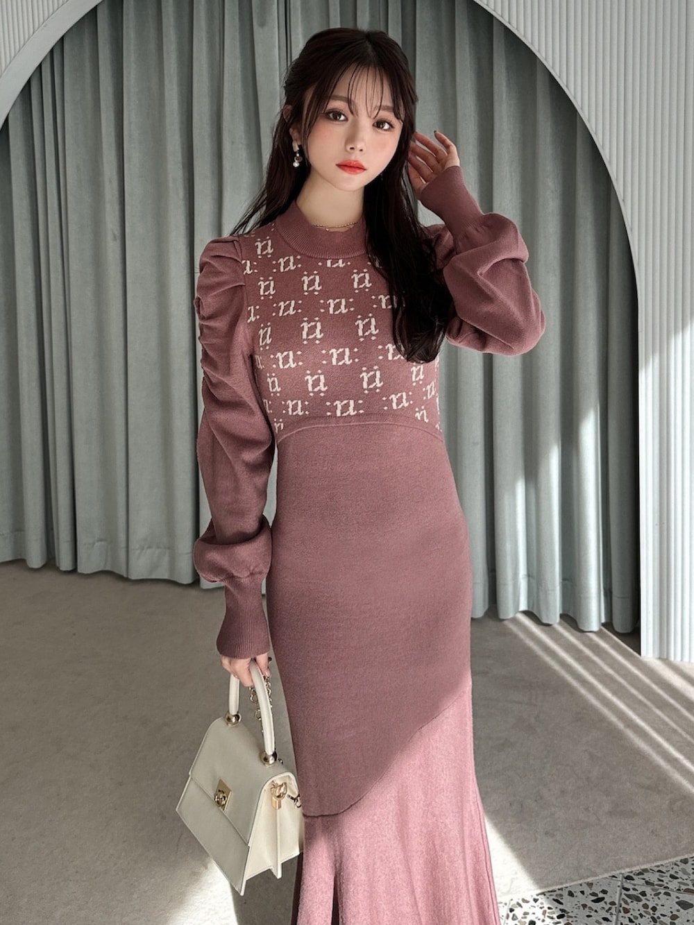 ブラウン系のワンピース、ホワイト系のパンプス、ホワイト系のハンドバッグを着用したレディースの冬コーディネートの5枚目の写真