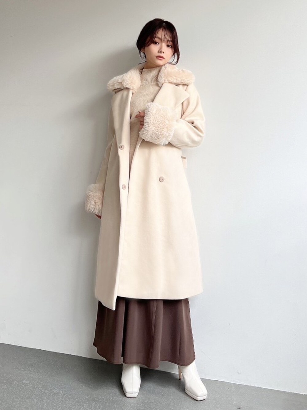ホワイト系のその他アウター、ベージュ系のニット/セーター、ブラウン系のスカートを着用したレディースの冬コーディネートの3枚目の写真