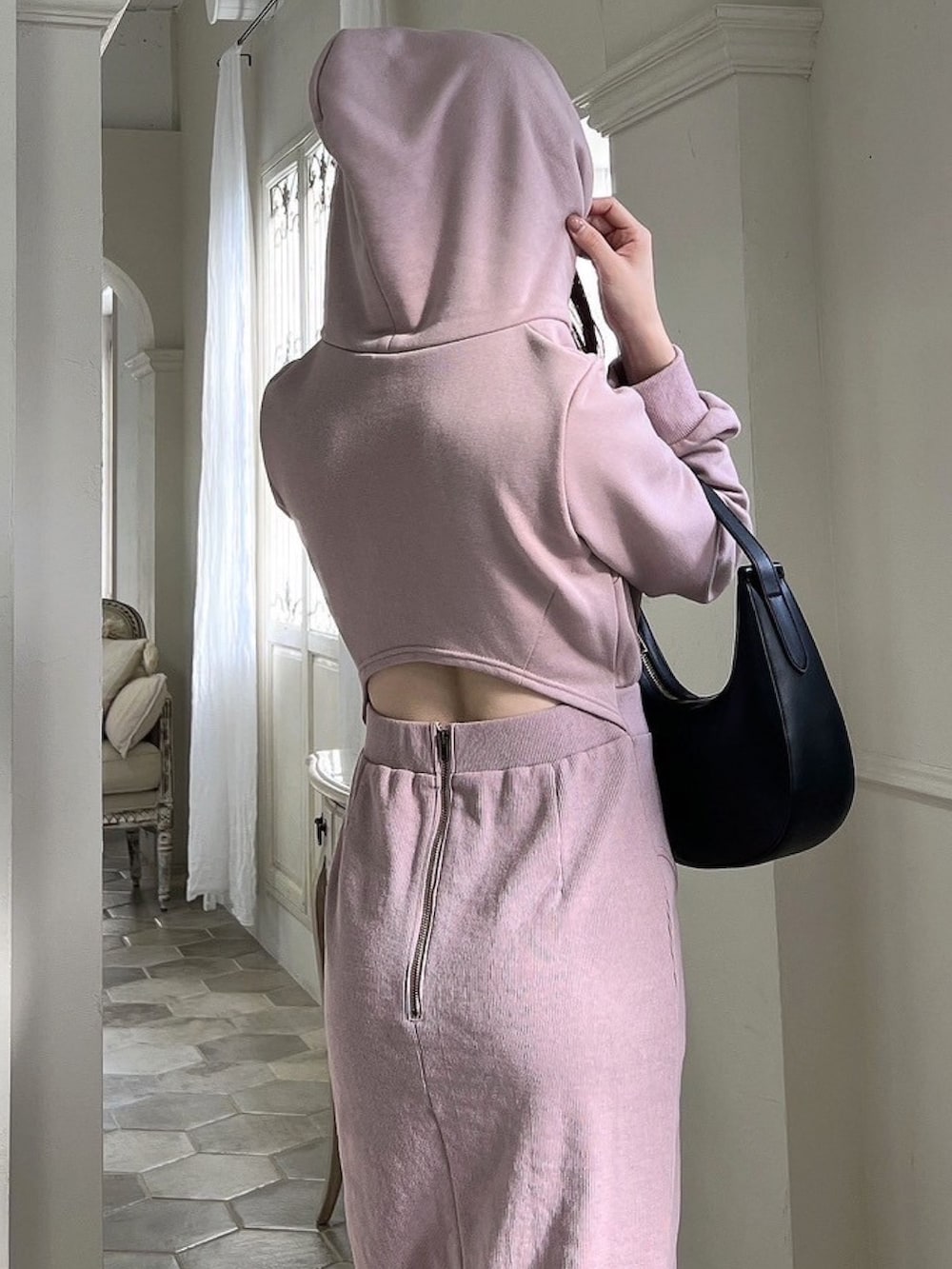 ピンク系のワンピース、ブラック系のハンドバッグ、ブラック系のブーツを着用したレディースの冬コーディネートの3枚目の写真