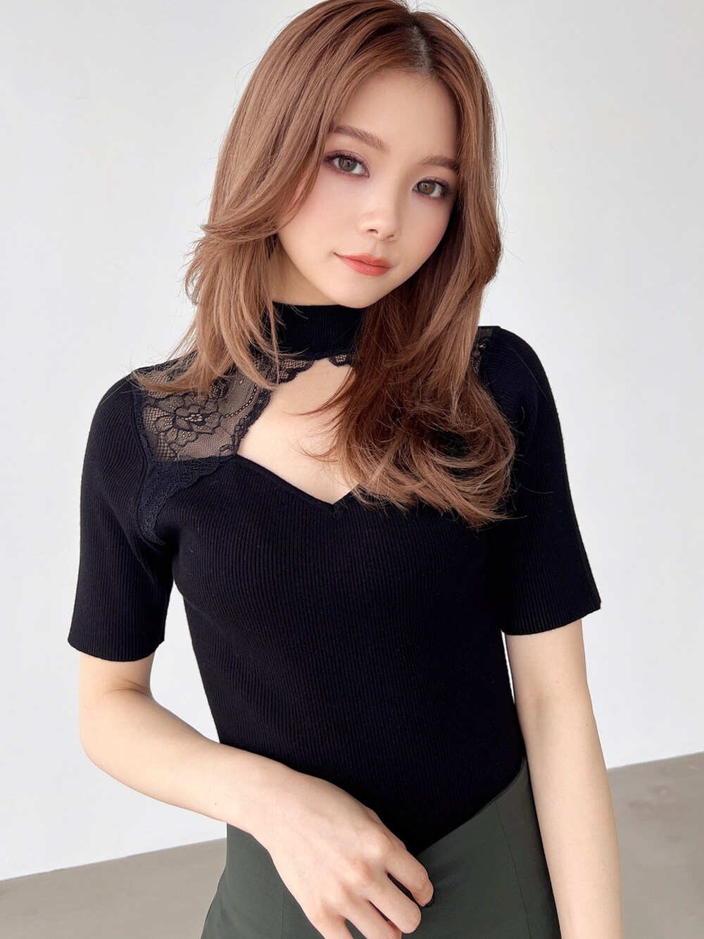 グリーン系のスカート、ブラック系のパンプス、ブラック系のニット/セーターを着用したレディースの夏コーディネートの3枚目の写真