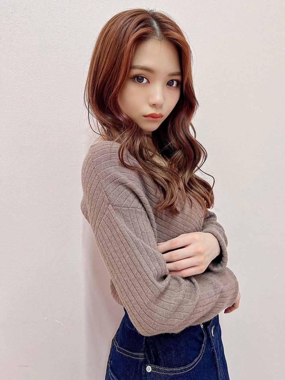 ブルー系のスカート、ブラック系のブーツ、ベージュ系のニット/セーターを着用したレディースの秋コーディネートの3枚目の写真