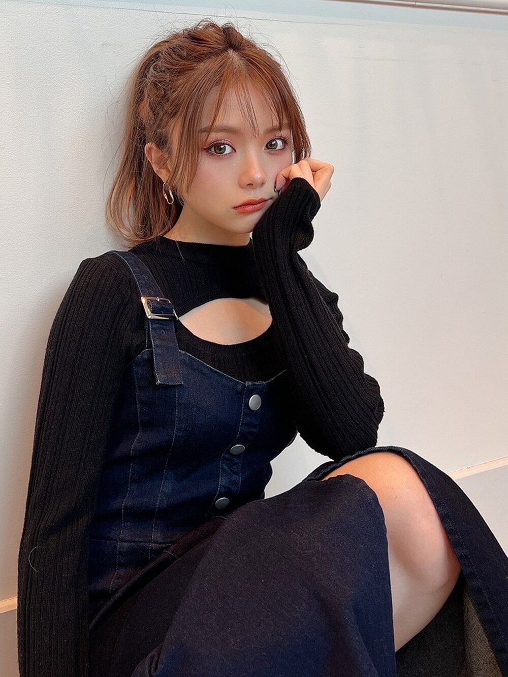 ブラック系のニット/セーター、ブルー系のジャンパースカート、ベージュ系のサンダルを着用したレディースの冬コーディネートの4枚目の写真