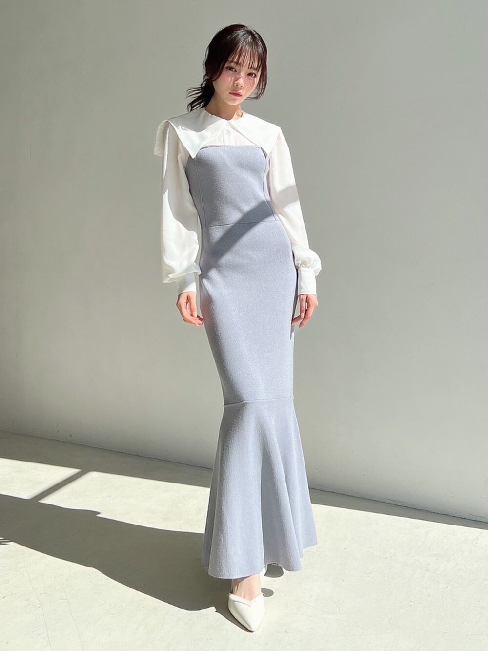 ブルー系のワンピース、ホワイト系のトレンチコートを着用したレディースの冬コーディネートの2枚目の写真