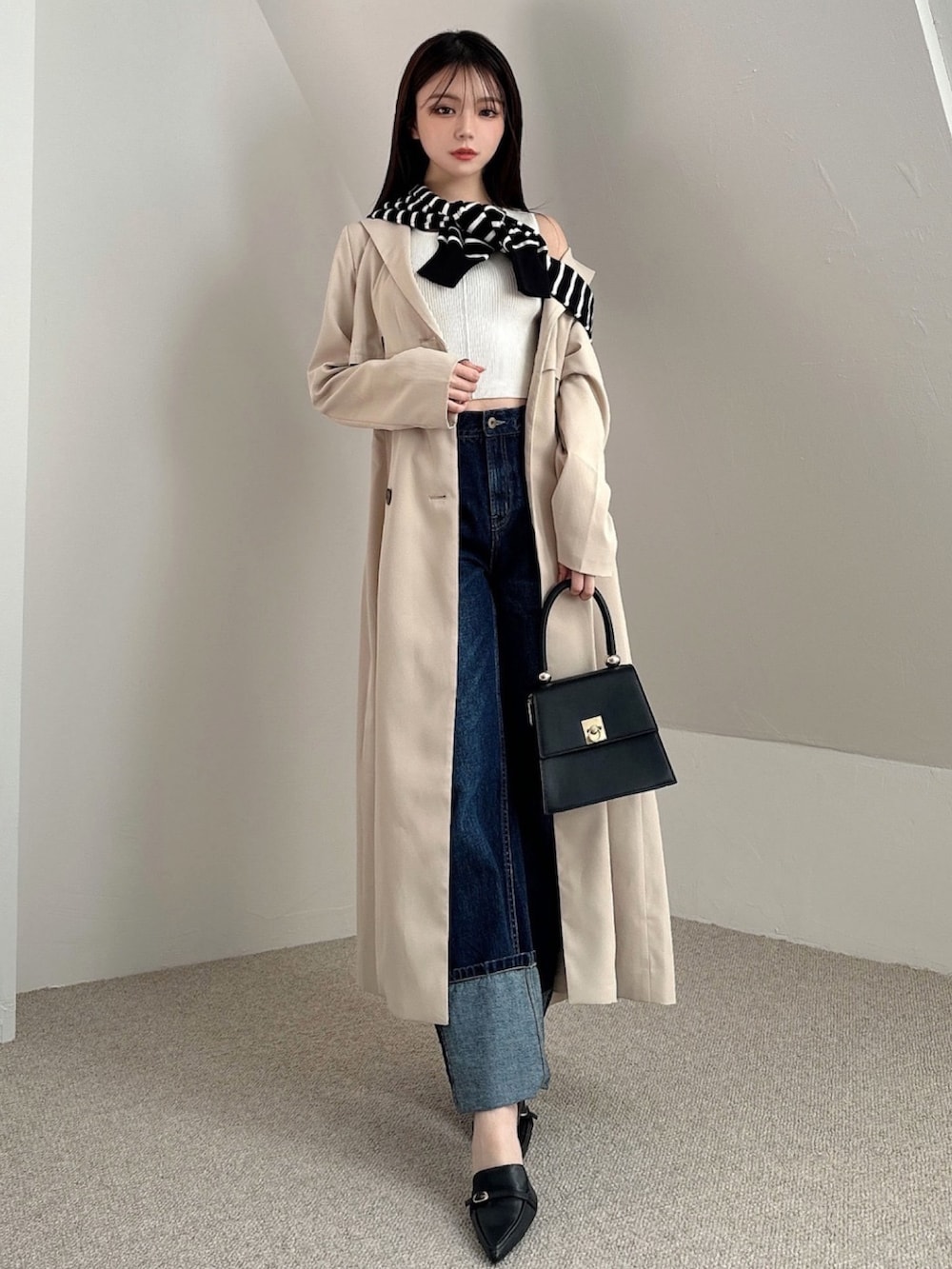 ベージュ系のトレンチコート、その他のカーディガン/ボレロ、ブルー系のデニムパンツを着用したレディースの冬コーディネートの3枚目の写真