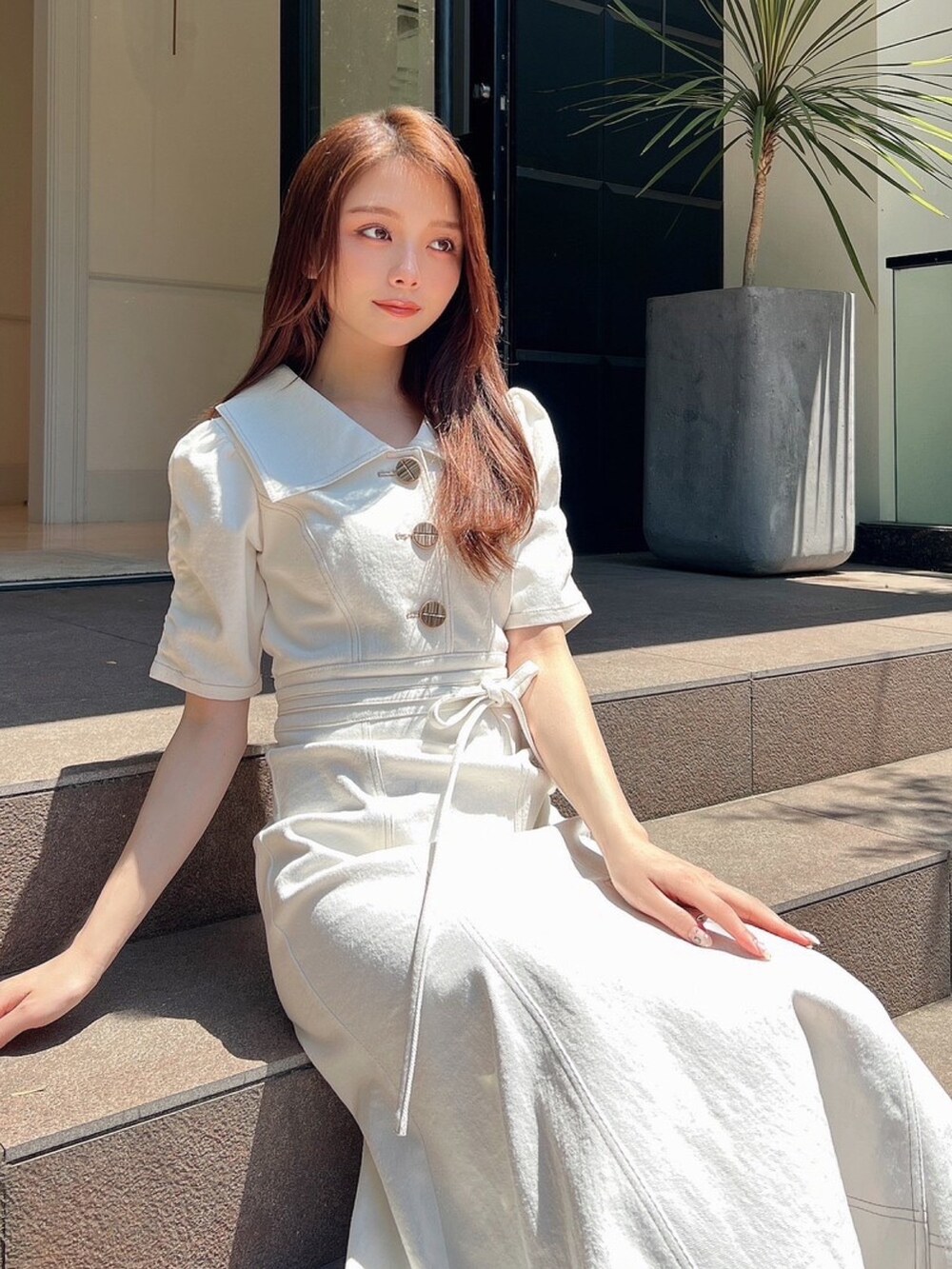 ホワイト系のワンピース、ホワイト系のサンダルを着用したレディースの夏コーディネートの3枚目の写真