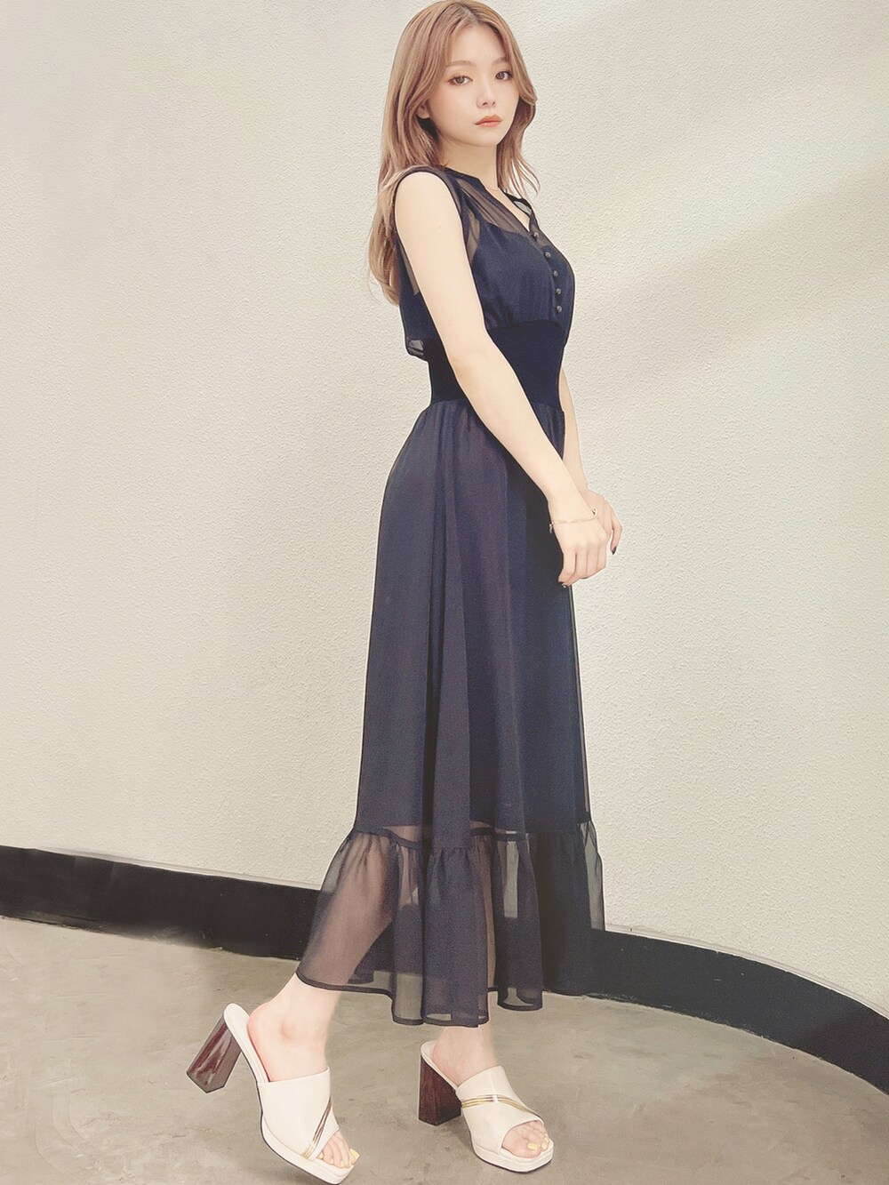 ホワイト系のサンダル、ブラック系のワンピースを着用したレディースの夏コーディネートの2枚目の写真