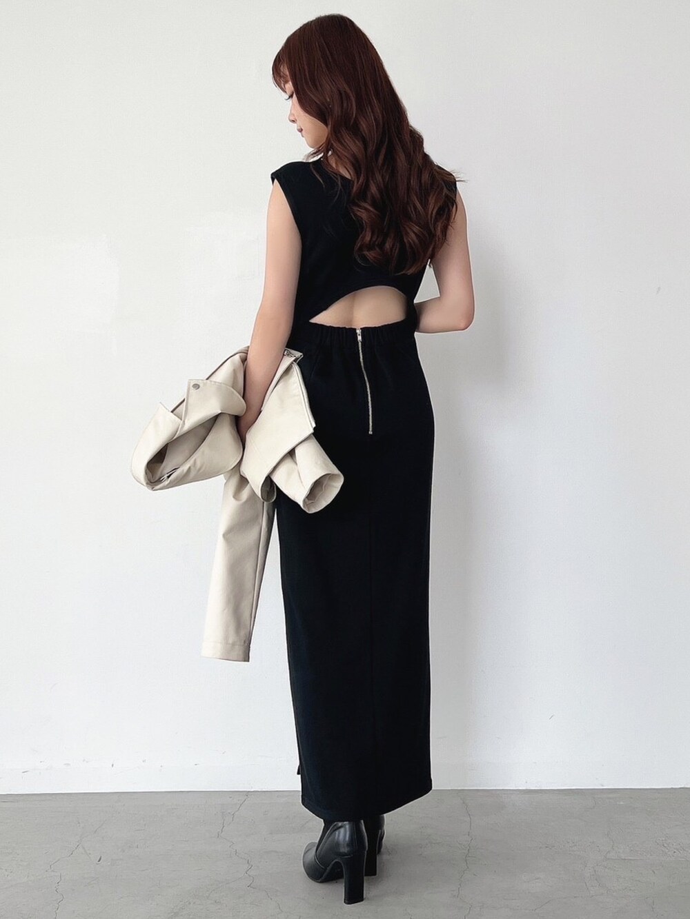 ホワイト系のライダースジャケット、ブラック系のワンピース、ゴールド系のピアス（両耳用）を着用したレディースの秋コーディネートの2枚目の写真