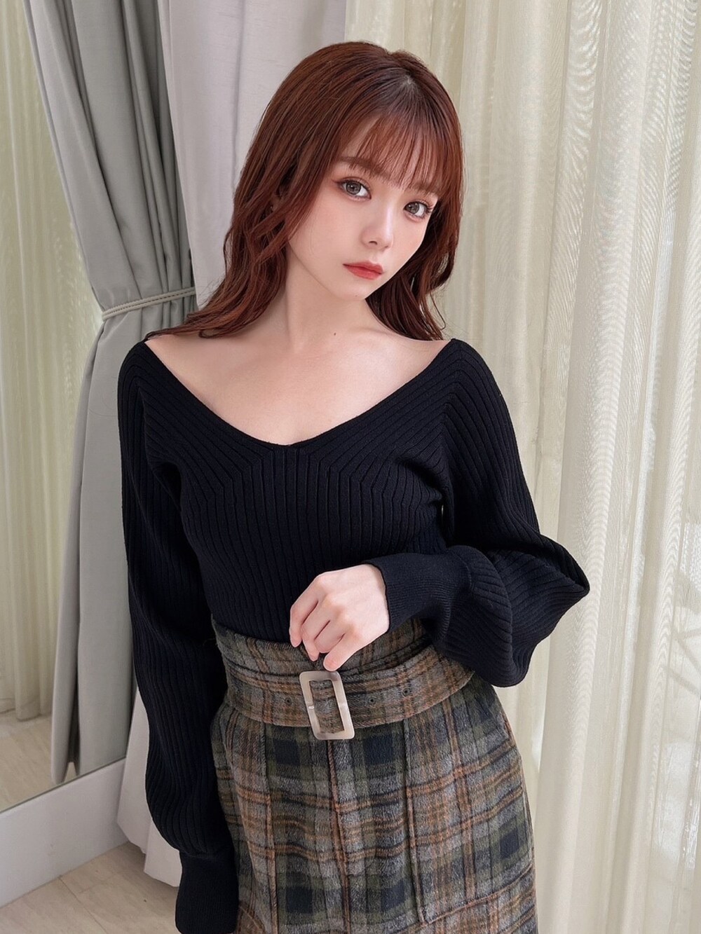 ブラウン系のブーツ、ブラウン系のチェスターコート、ブラック系のニット/セーターを着用したレディースの秋コーディネートの3枚目の写真