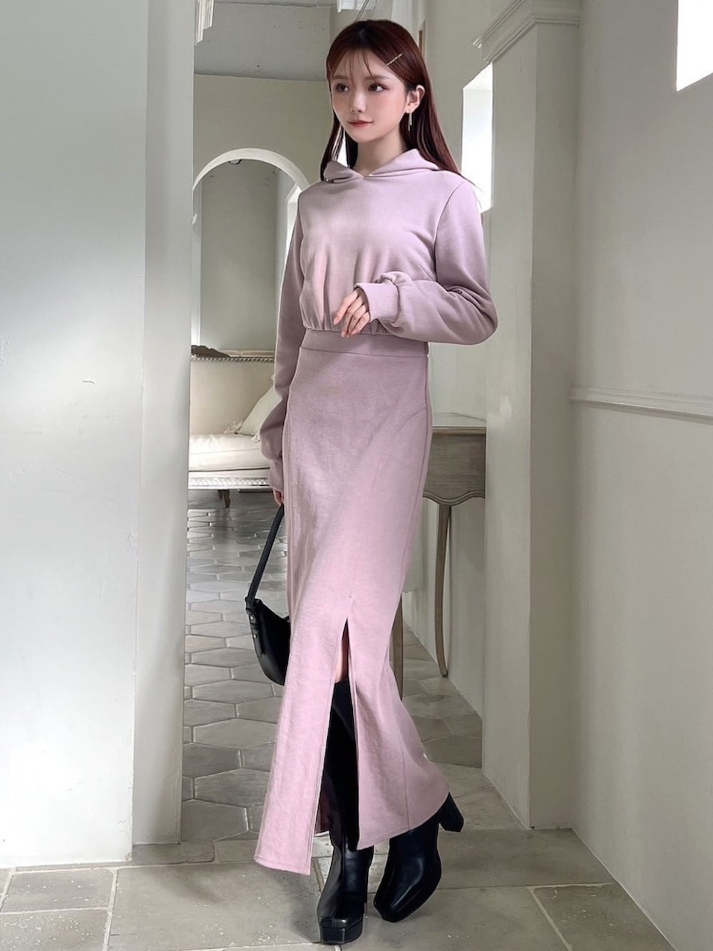 ピンク系のワンピース、ブラック系のハンドバッグ、ブラック系のブーツを着用したレディースの冬コーディネートの6枚目の写真