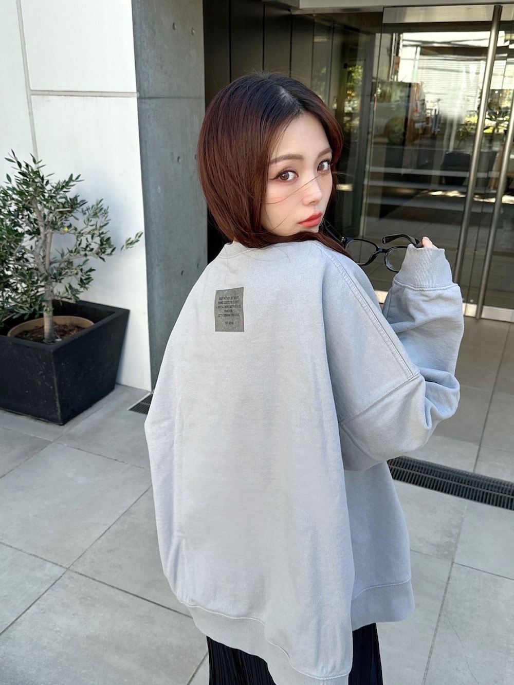 グレー系のスウェット、ブラック系のスカートを着用したレディースの春コーディネートの6枚目の写真