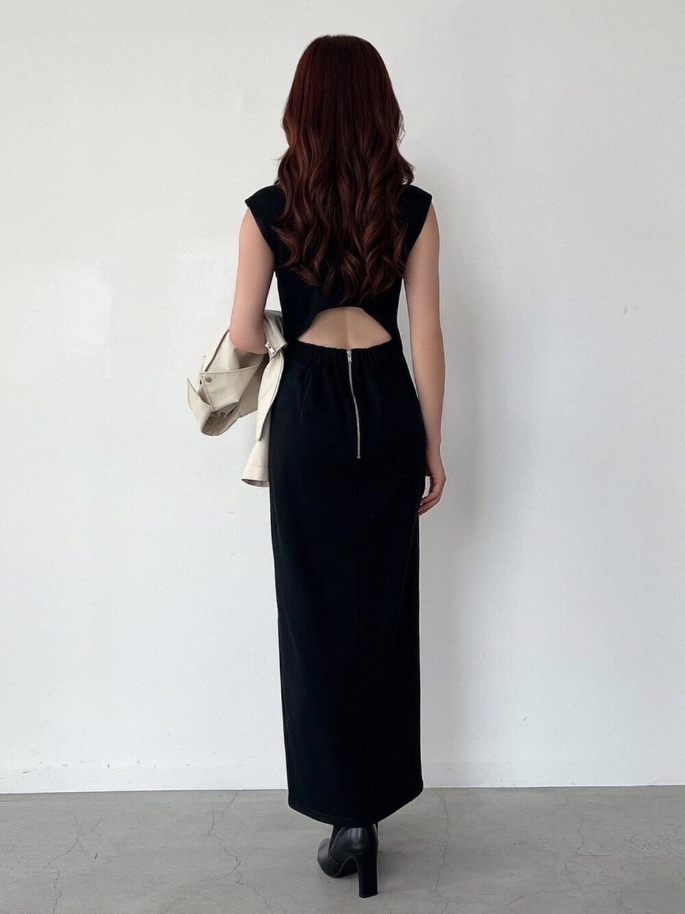 ホワイト系のライダースジャケット、ブラック系のワンピース、ゴールド系のピアス（両耳用）を着用したレディースの秋コーディネートの4枚目の写真