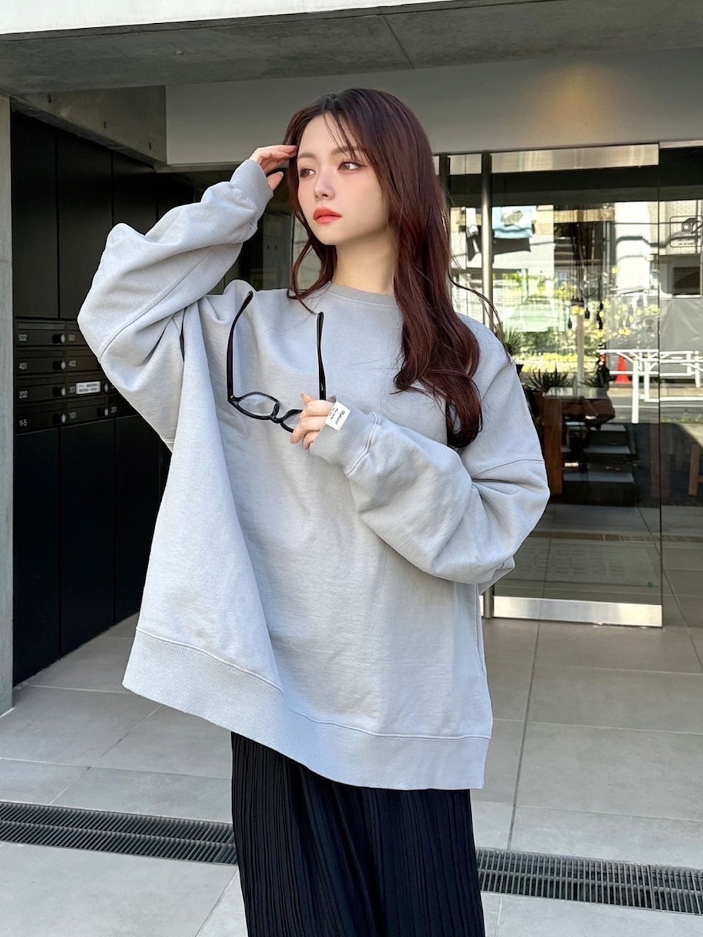 グレー系のスウェット、ブラック系のスカートを着用したレディースの春コーディネートの5枚目の写真