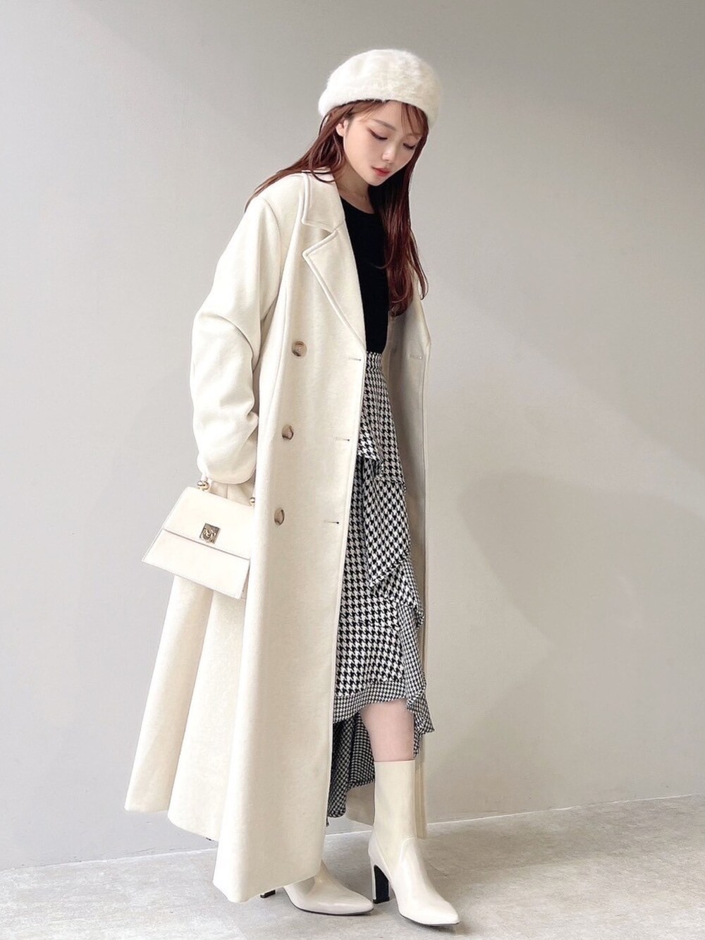 ホワイト系のチェスターコート、ホワイト系のハンドバッグ、ホワイト系のブーツを着用したレディースの秋コーディネートの7枚目の写真