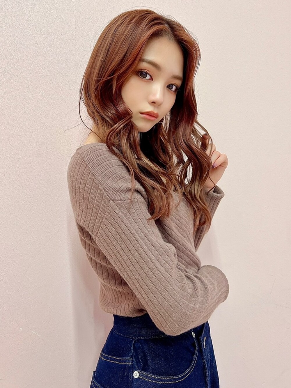 ブルー系のスカート、ブラック系のブーツ、ベージュ系のニット/セーターを着用したレディースの秋コーディネートの2枚目の写真