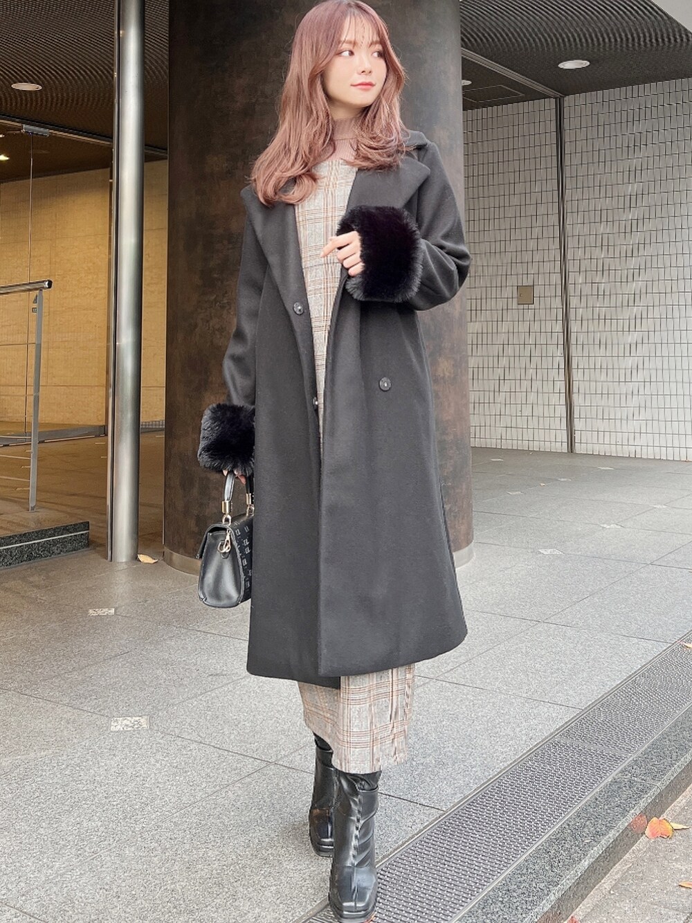 ブラウン系のワンピース、ブラック系のその他アウター、ブラック系のハンドバッグを着用したレディースの秋コーディネートの3枚目の写真