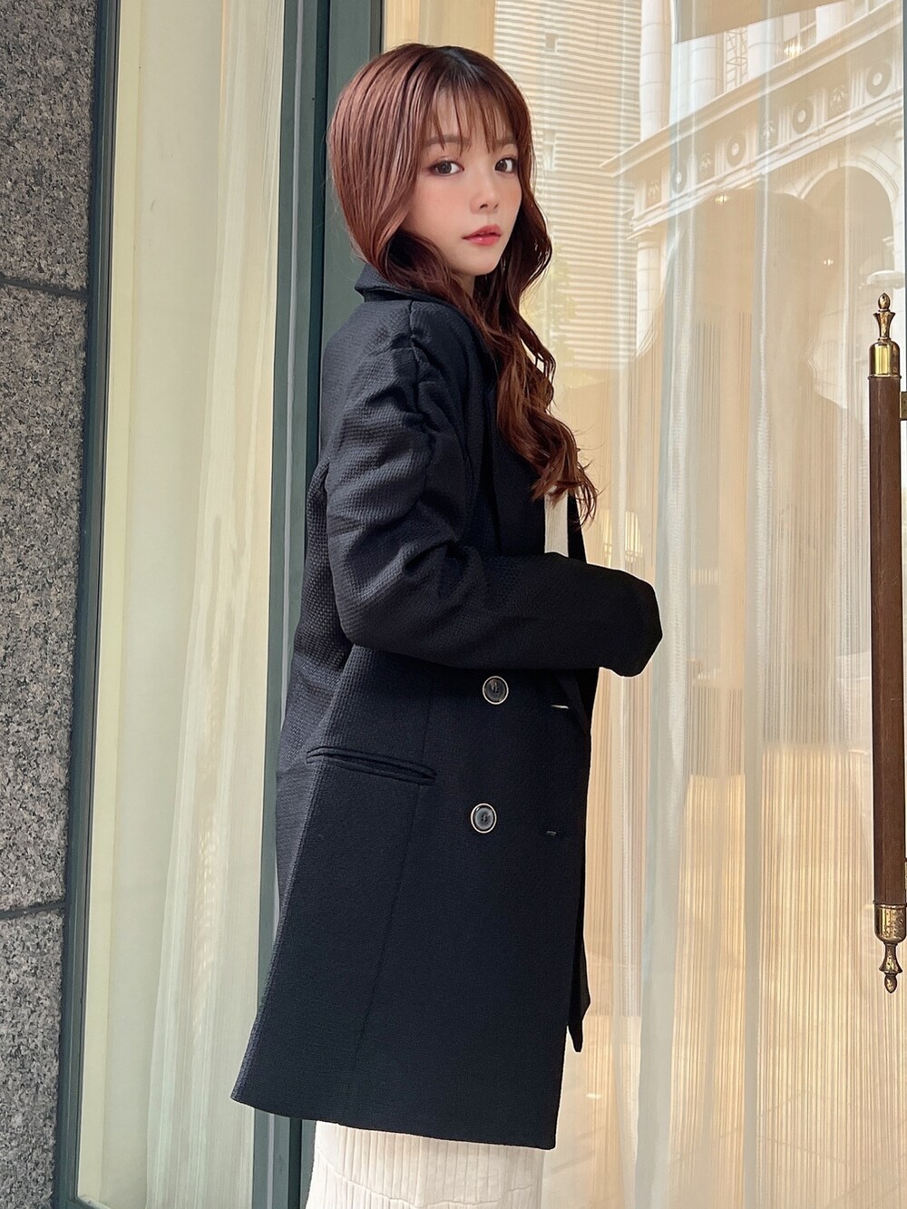 ブラック系のテーラードジャケット、ホワイト系のワンピースを着用したレディースの秋コーディネートの4枚目の写真