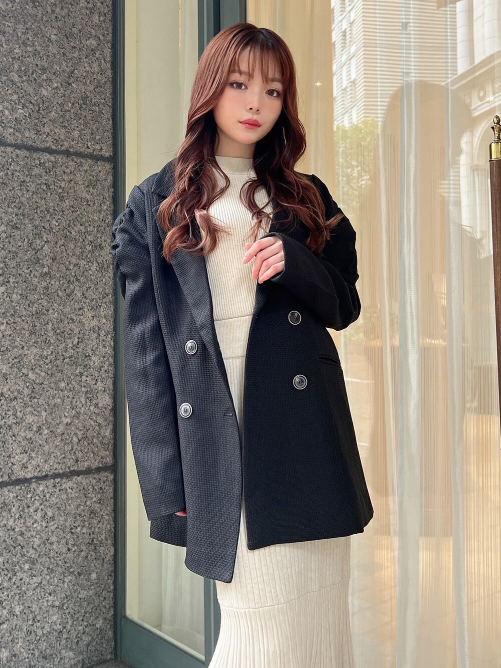 ブラック系のテーラードジャケット、ホワイト系のワンピースを着用したレディースの秋コーディネートの3枚目の写真