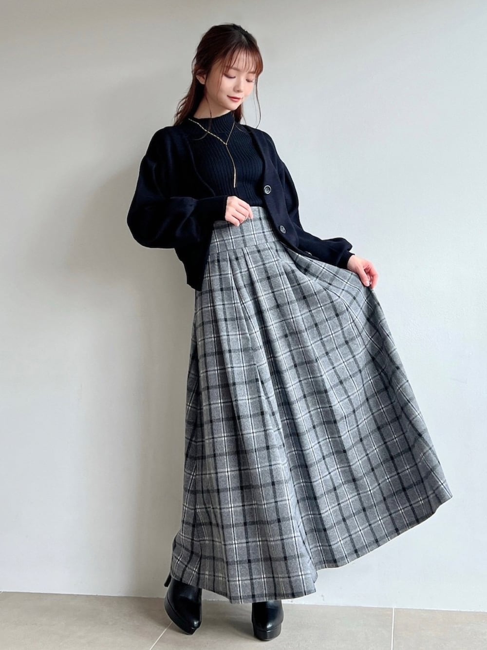 ブラック系のスカート、ブラック系のカーディガン/ボレロ、ブラック系のニット/セーターを着用したレディースの冬コーディネートの2枚目の写真