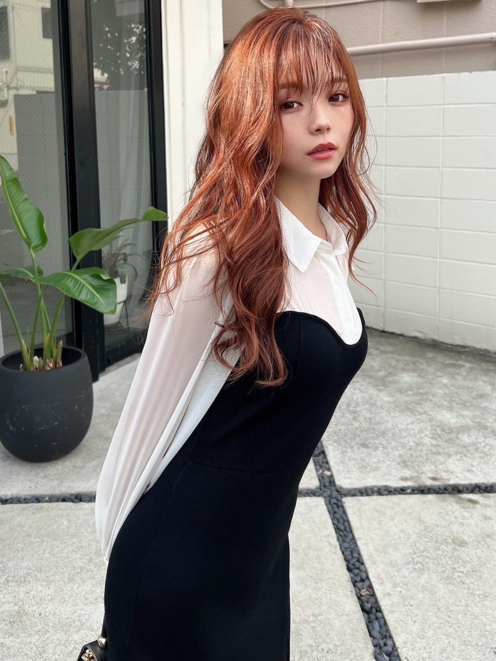 ブラック系のワンピース、ブラック系のハンドバッグ、ブラック系のブーツを着用したレディースの秋コーディネートの4枚目の写真