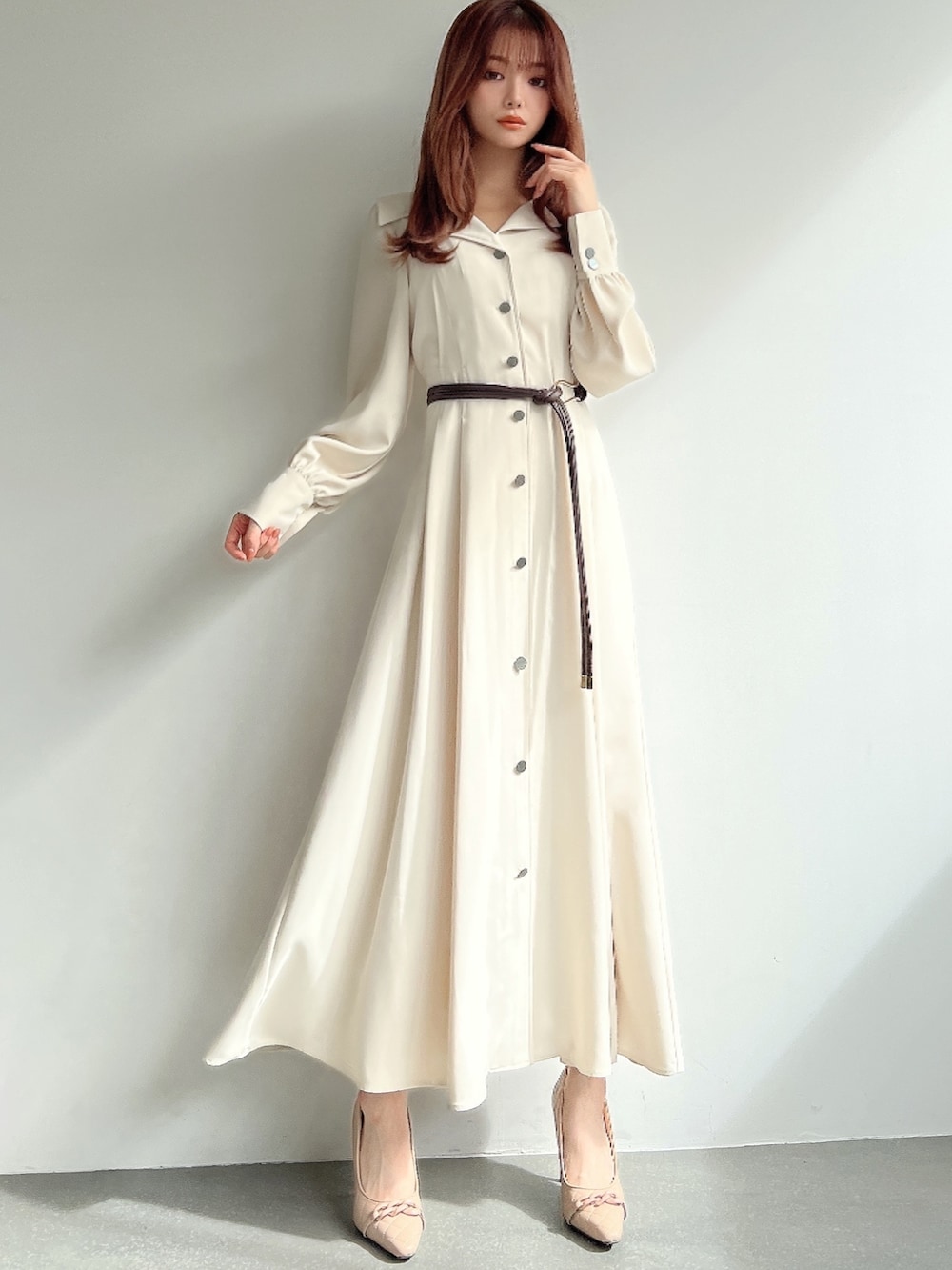 ホワイト系のワンピース、ベージュ系のパンプス、ブラウン系のベルトを着用したレディースの冬コーディネートの2枚目の写真