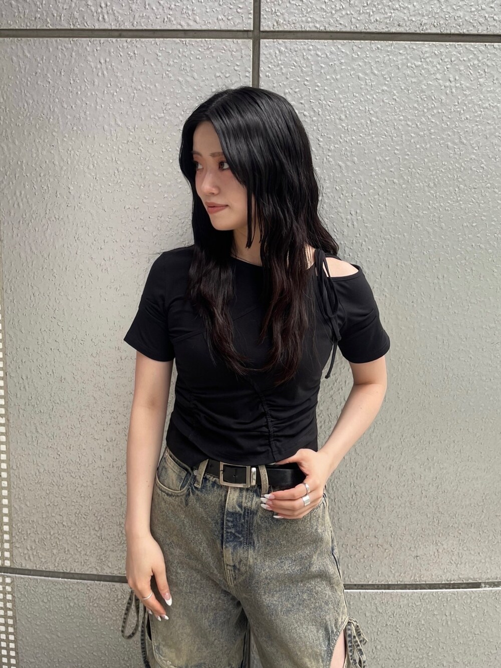 ブルー系のデニムパンツ、ブラック系のTシャツ/カットソー、ブラック系のサンダルを着用したレディースの春コーディネートの6枚目の写真