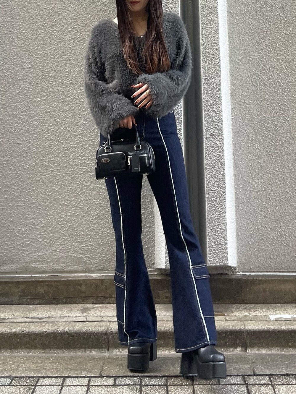 ブルー系のデニムパンツ、グレー系のニット/セーター、ブラック系のブーツを着用したレディースの秋コーディネートの3枚目の写真