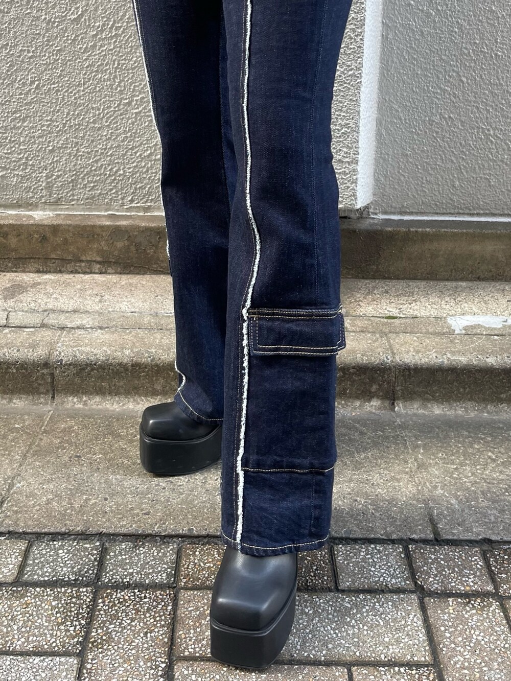 ブルー系のデニムパンツ、グレー系のニット/セーター、ブラック系のブーツを着用したレディースの秋コーディネートの4枚目の写真