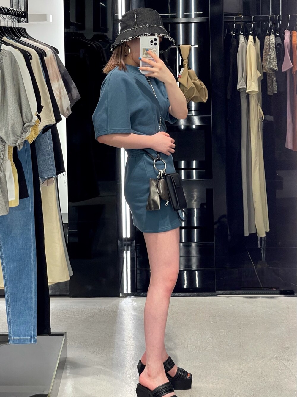 ブルー系のワンピース、ブラック系のサンダル、ブラック系のショルダーバッグを着用したレディースの夏コーディネートの4枚目の写真