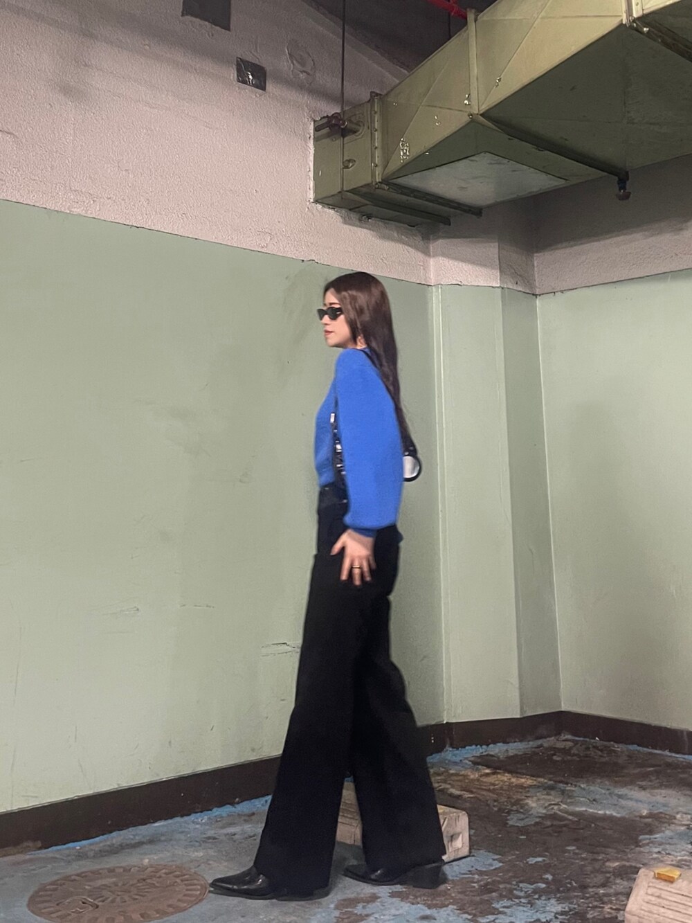 ブルー系のニット/セーター、ブラック系のデニムパンツを着用したレディースの冬コーディネートの4枚目の写真