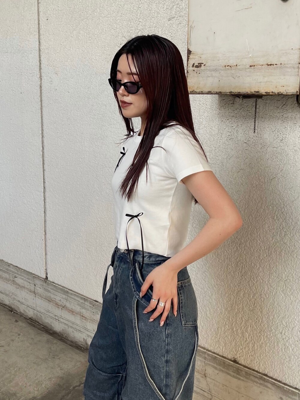 ホワイト系のTシャツ/カットソー、ブラック系のサンダル、ブルー系のデニムパンツを着用したレディースの夏コーディネートの7枚目の写真