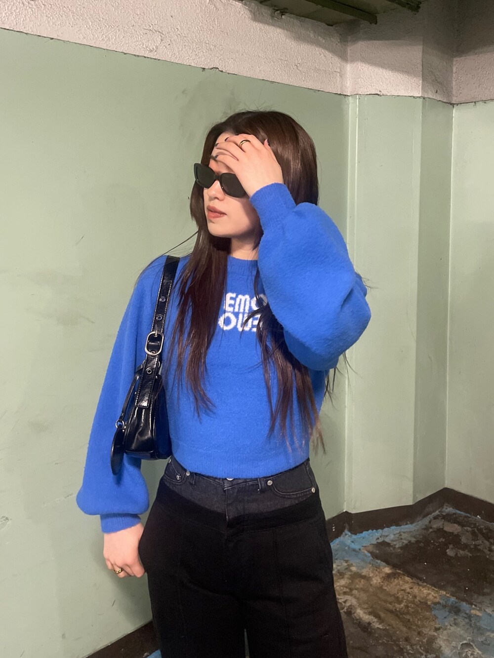 ブルー系のニット/セーター、ブラック系のデニムパンツを着用したレディースの冬コーディネートの5枚目の写真