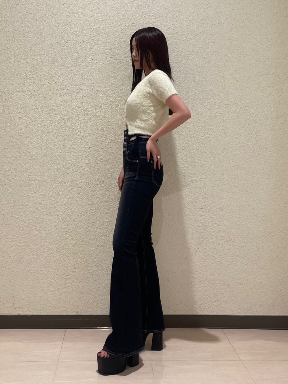 ブルー系のデニムパンツ、ホワイト系のニット/セーター、ブラック系のサンダルを着用したレディースの夏コーディネートの3枚目の写真